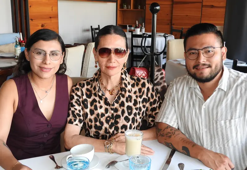 Graciela del Carmen López Aguilar celebra su cumpleaños en Oaxaca, posando sonriente al centro, acompañada por su hijo Andrés y su nuera Andrea.