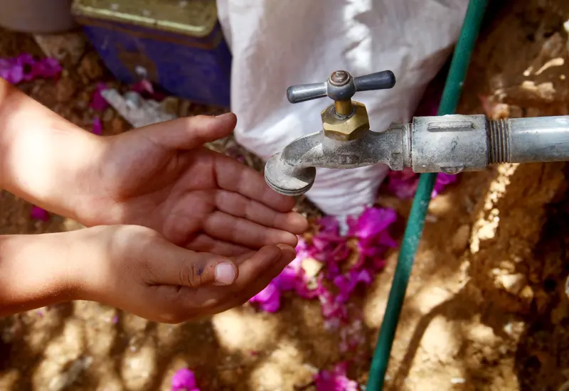 Manos de una persona recibiendo agua potable de un grifo, simbolizando que el consumo humano es prioridad con la nueva Ley de Aguas.