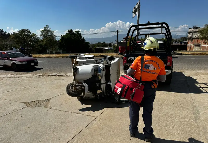 Un mototaxi volcado sobre la carretera federal 175 tras un choque con una patrulla, accidente que dejó a una mujer lesionada.