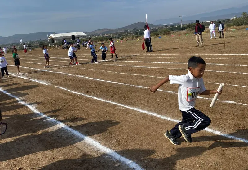 Un grupo de niños competidores dan su mejor esfuerzo durante una olimpiada deportiva, buscando con esperanza un lugar en el podio de los ganadores.