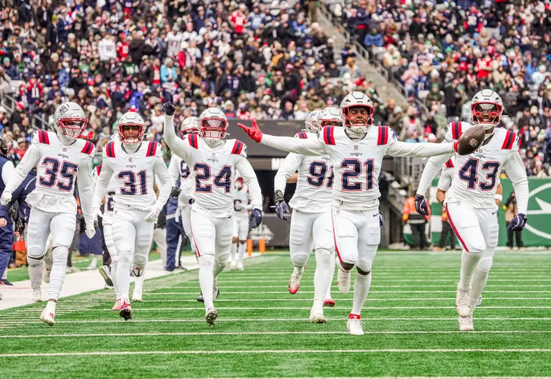 Jugadores de los Patriots en acción durante el partido de fútbol americano contra los Jets, manteniendo el buen paso hacia los playoffs.