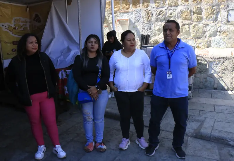 Varios puestos de vendedores ambulantes instalados sobre la banqueta justo en la entrada de una escuela primaria, obstaculizando el paso y generando riesgo para los alumnos.