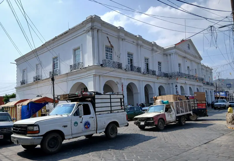 Recolectores de basura utilizan sus camiones para bloquear una calle en Tehuantepec como protesta contra las autoridades municipales por daños a una sepultura.