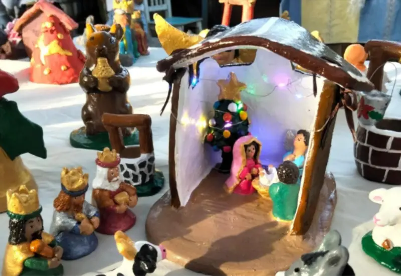 Asistentes del taller navideño de figuras de barro muestran las piezas personalizadas que desarrollaron durante la actividad creativa.