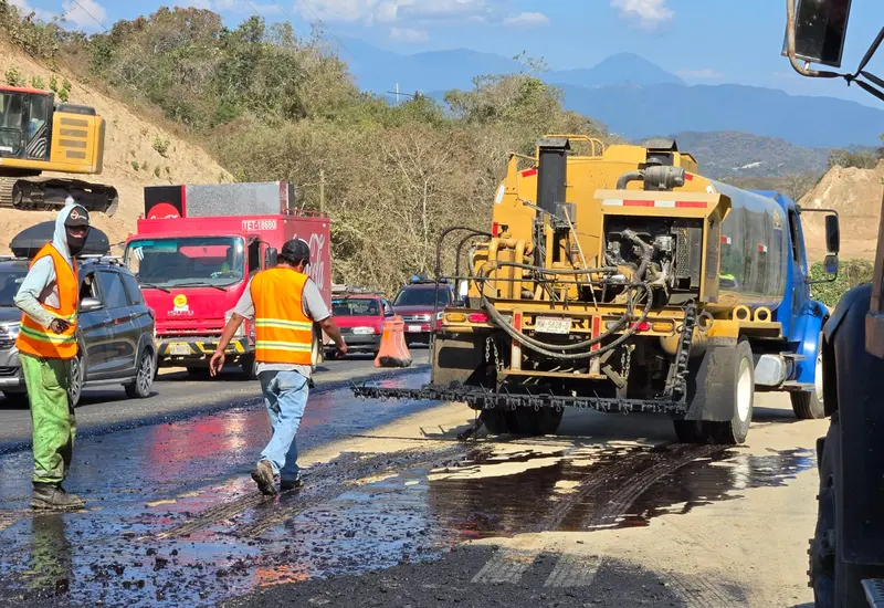 Trabajadores y maquinaria pesada realizando obras de modernización en la carretera federal que conecta a Pochutla con Huatulco, supervisadas por la SICT.