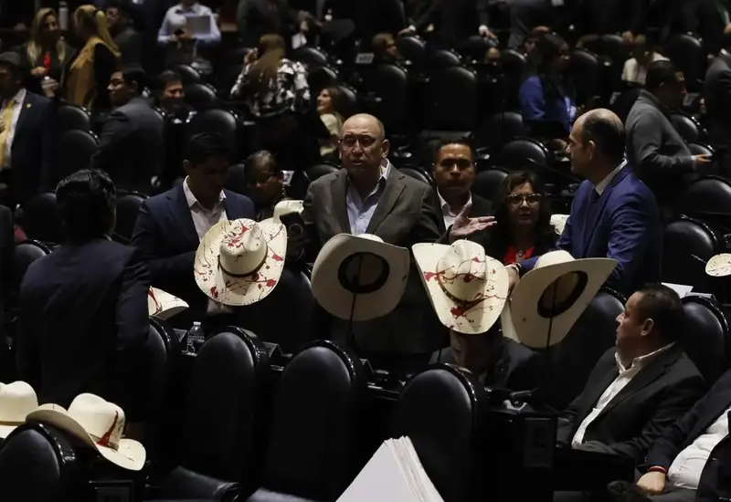Diputados con sombreros manchados de rojo guardan un minuto de silencio y aplauden en memoria del presidente municipal de Uruapan, Carlos Manzo.