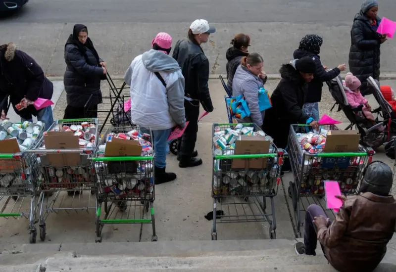 Un grupo de personas hace fila para recoger alimentos de donación en la sede de la organización Care for Real en Chicago.