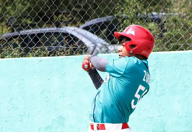Un jugador de béisbol en acción durante el partido final de la Liga Vasconcelos, dando su máximo esfuerzo en busca del título.