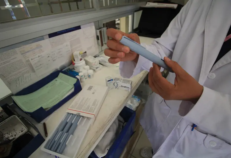 Personal de salud del IMSS realiza una prueba de detección de diabetes a un paciente durante una feria de prevención y salud.