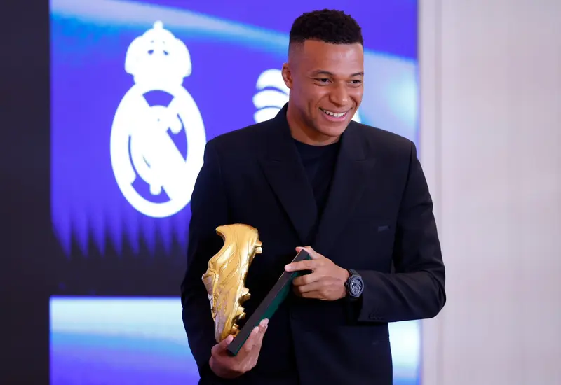 El delantero francés Kylian Mbappé sostiene su trofeo de la Bota de Oro, premio que lo reconoce como el máximo goleador.