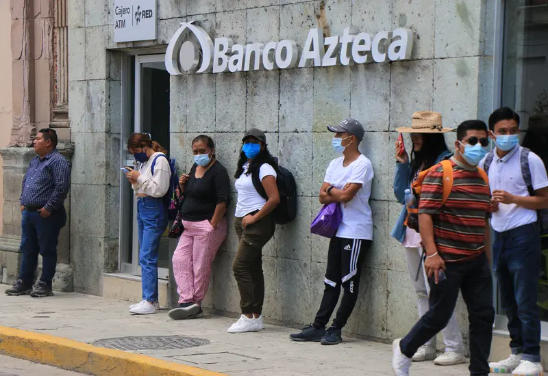 Una persona realiza un pago utilizando billetes de pesos mexicanos, reflejando la preferencia por el efectivo a pesar del avance de la banca digital.
