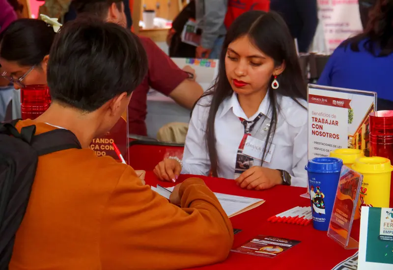 Una joven trabajadora en México muestra un gesto de inconformidad, reflejando el estancamiento de la satisfacción laboral que afecta a las mujeres.