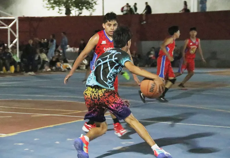 Jóvenes jugadores de baloncesto compiten intensamente en la duela durante el primer día de competencia del torneo de la Liga Telmex.