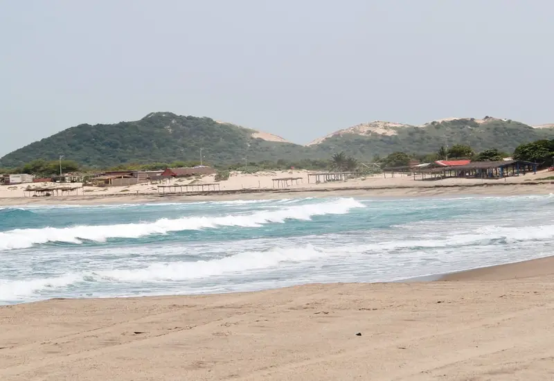Prestadores de servicios turísticos en una playa concurrida, esperando un repunte económico durante el periodo vacacional de mayor consumo para el sector.