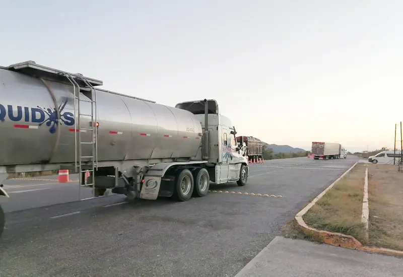 Un tráiler con caja vacía transita por una carretera del Istmo de Tehuantepec, vulnerable a volcaduras por los fuertes vientos del frente frío.