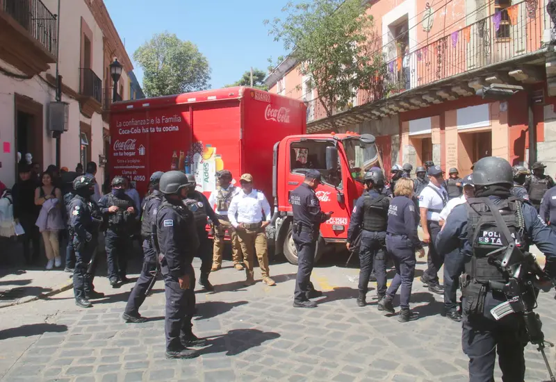 Elementos de la policía estatal intervienen para desalojar a estudiantes normalistas que mantenían un bloqueo en la vía pública.