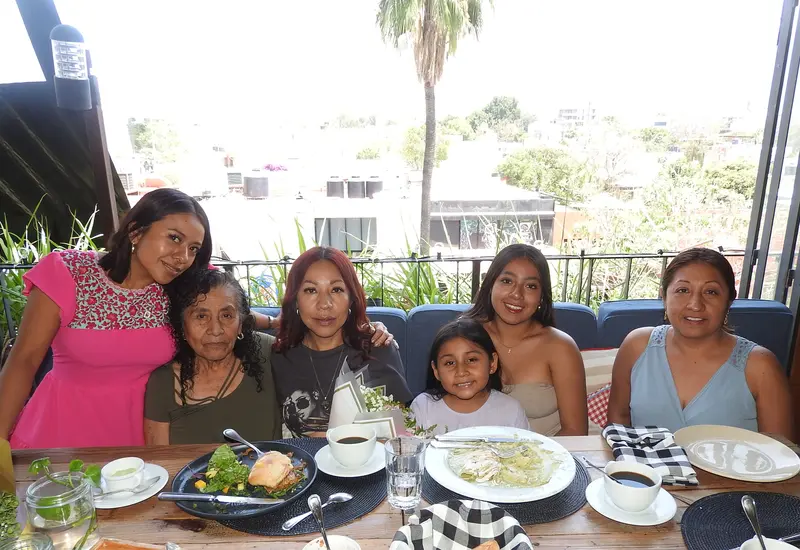 Silvia Ramírez celebra su cumpleaños en una reunión familiar, sonriendo rodeada del cariño de sus hijas, su mamá y su hermana.