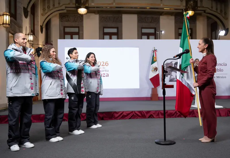 La presidenta Claudia Sheinbaum realiza el abanderamiento de la delegación mexicana, entregando la bandera nacional en una ceremonia oficial.
