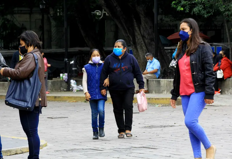 Una persona bien abrigada camina por una calle solitaria, ilustrando las bajas temperaturas que marcan el inicio del año 2026.