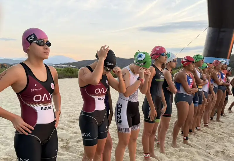 Jóvenes atletas se preparan en la línea de salida para la competencia de triatlón de la Olimpiada Estatal, buscando su pase a Veracruz.