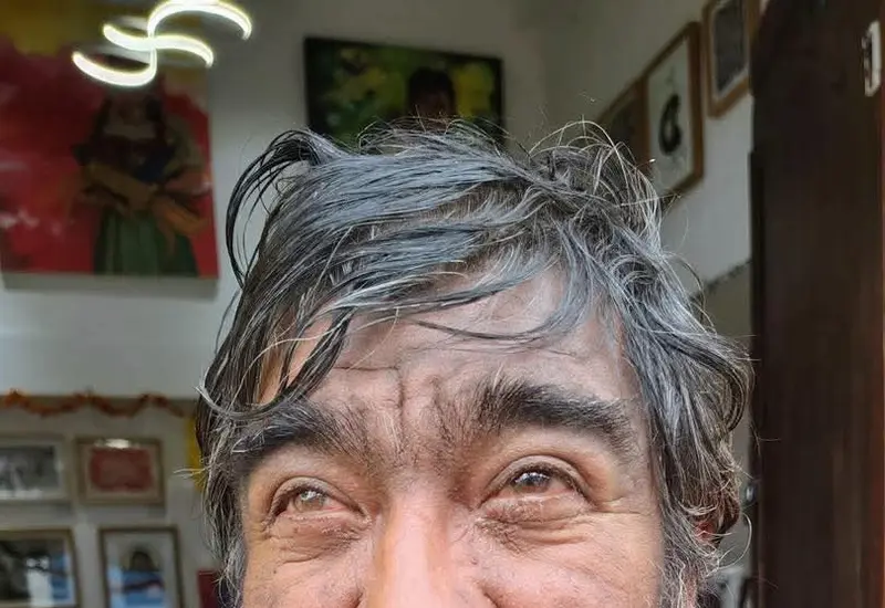 Un hombre, figura familiar para los habitantes del centro de la ciudad, sonríe a la cámara iluminando la calle con su gesto amable.