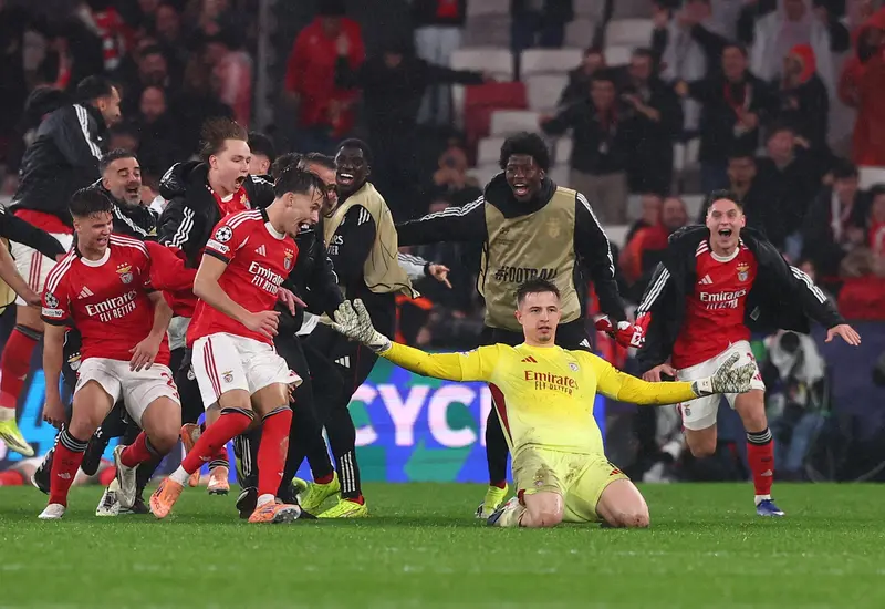 El equipo de Benfica celebra su histórica remontada contra el Real Madrid, un resultado que deja al equipo merengue fuera del Top 8.