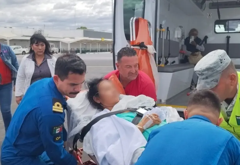 Una mujer lesionada del Tren Interoceánico recibe atención médica por parte de paramédicos antes de ser trasladada al IMSS de la ciudad de Oaxaca.