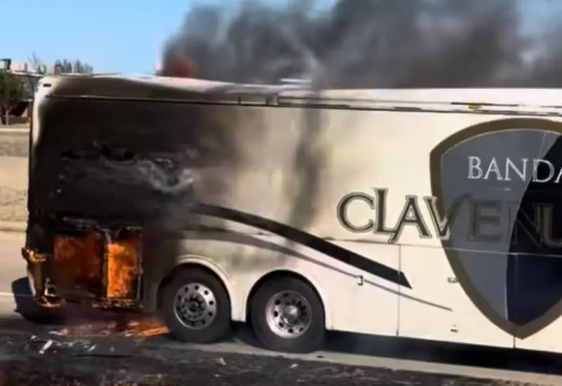 El autobús de la agrupación musical Banda Clave Nueva envuelto en llamas a un costado de la carretera, sin que se reportaran heridos.