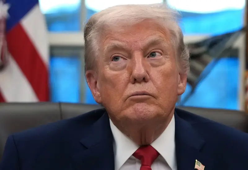 El expresidente Donald Trump emitiendo un discurso con gesto serio, en relación a los nuevos aranceles y amenazas contra los aliados de Irán.