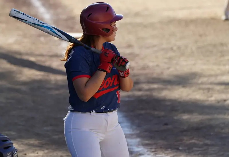 Una jugadora experimentada de la liga de softbol femenil Primera Fuerza se concentra en el diamante durante un intenso duelo por el campeonato.