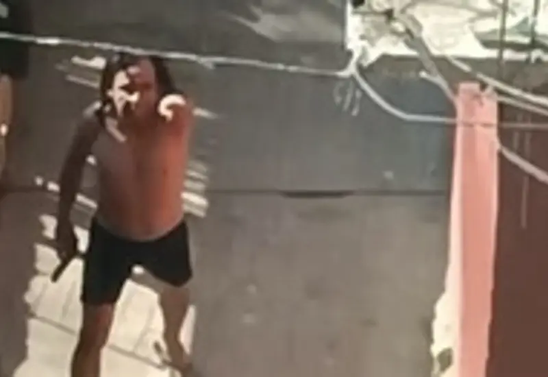 Felipe Rodrigo, con una pistola en la mano, reta a elementos de la policía en el patio de su vivienda en la colonia Adolfo López Mateos.