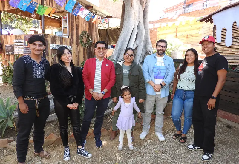 Óscar y Lila, al centro de la imagen, celebran su cumpleaños sonriendo felices en compañía de sus amigos y familiares durante el festejo.