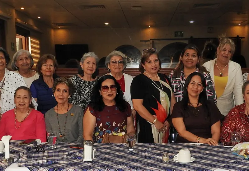 La apreciada Liliana Rivas Torruco, usando un vestido negro con flor, celebra su cumpleaños rodeada de familiares y amigas durante un festejo.