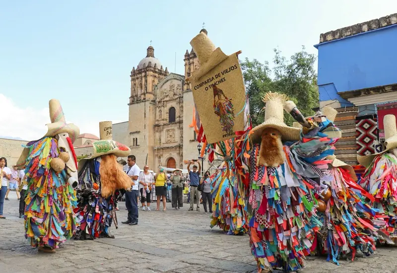Un contingente con trajes coloridos desfila por las calles del Centro Histórico de Oaxaca durante la Muestra de Carnavales anunciada para 2026.