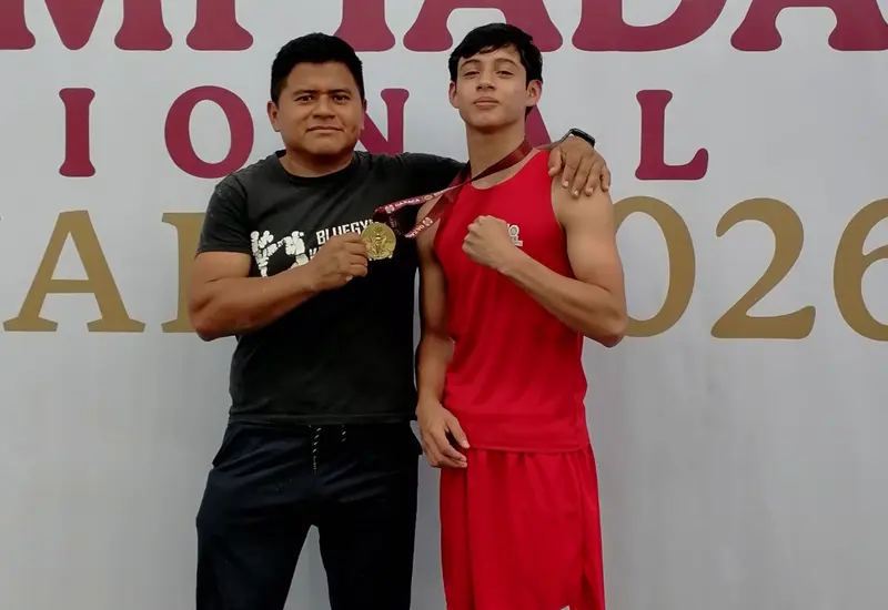 El pugilista Ramírez Urbiña posa para una fotografía al lado de su entrenador, tras ser convocado a la selección de boxeo.
