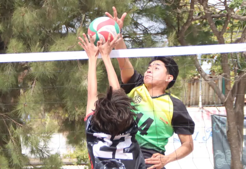 Jugadores de voleibol compiten durante el torneo comunitario celebrado en Manialtepec, un evento que fomenta la convivencia entre los participantes.