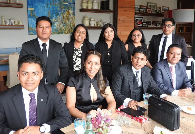 Un grupo de abogados y abogadas penalistas celebran felices el Día del Abogado, posando juntos durante una amena convivencia.