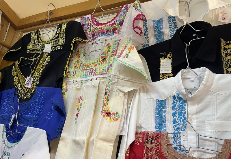 Una artesana de San José del Progreso demuestra la técnica del deshilado, retirando hilos de una tela para formar figuras culturales.
