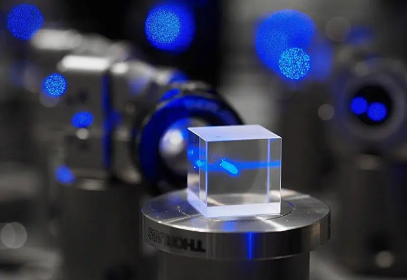 Ilustración conceptual de átomos ultrafríos dentro de un detector cuántico, tecnología del futuro para estudiar materia oscura y ondas gravitacionales con precisión.