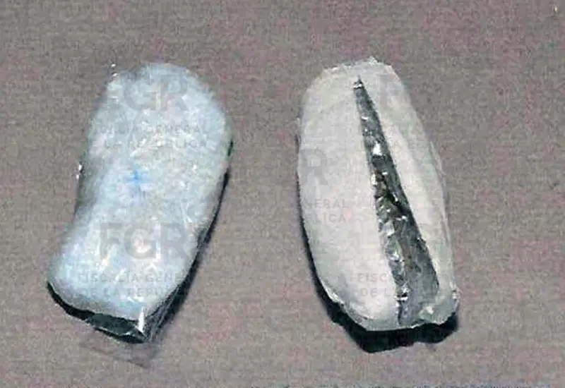 Paquetes de cocaína y marihuana decomisados a una visitante, exhibidos tras ser descubiertos en un maletín en el CEFERESO de Miahuatlán.