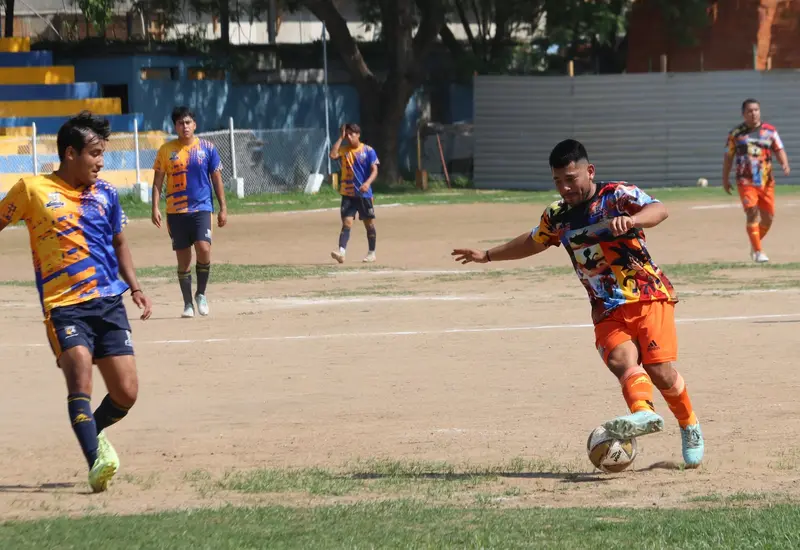 Dos equipos universitarios se enfrentan en el campo de juego durante la primera final de la Liga Mayor A, disputando el título de campeón.