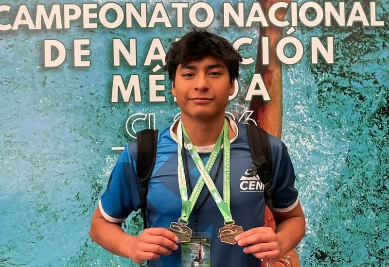 El nadador José David Contreras Adame posa orgulloso mostrando sus medallas de plata y bronce ganadas en la competencia de natación.