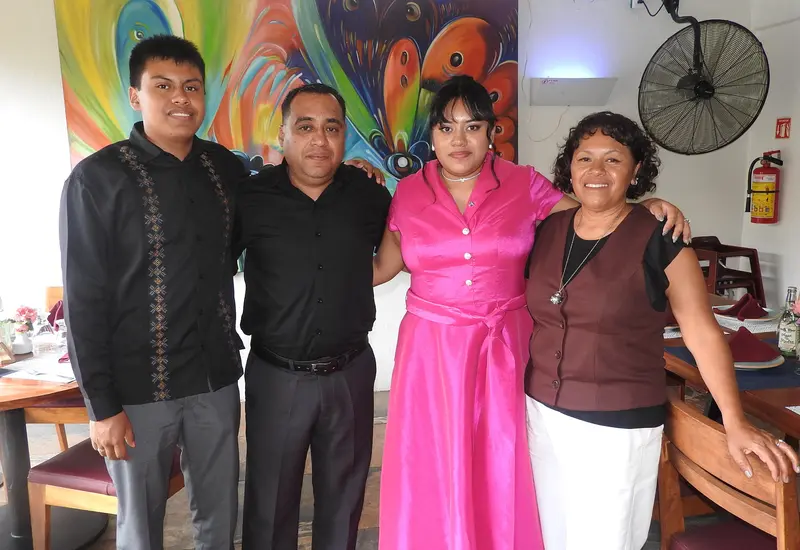 Juliana Haromi González Bernal celebra su graduación en Psicología de la Universidad La Salle, posando felizmente junto a sus padres y su hermano.