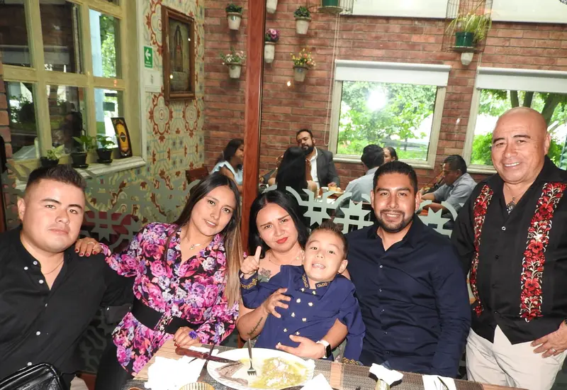 Matías Edalí Montero González celebra su graduación de preescolar, posando felizmente con sus padres, padrinos y su abuelito durante el festejo familiar.