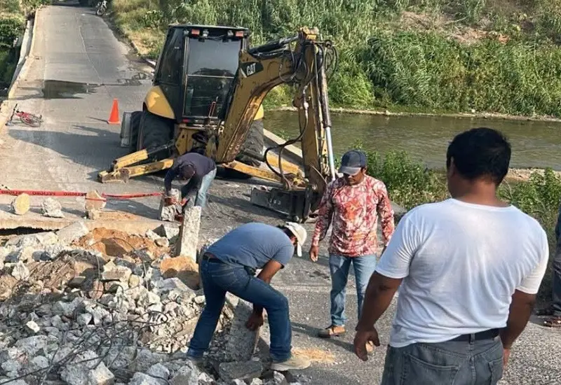 Personal de Protección Civil de Juchitán realiza trabajos de reparación en un vado, mientras la vía permanece abierta con restricciones preventivas.