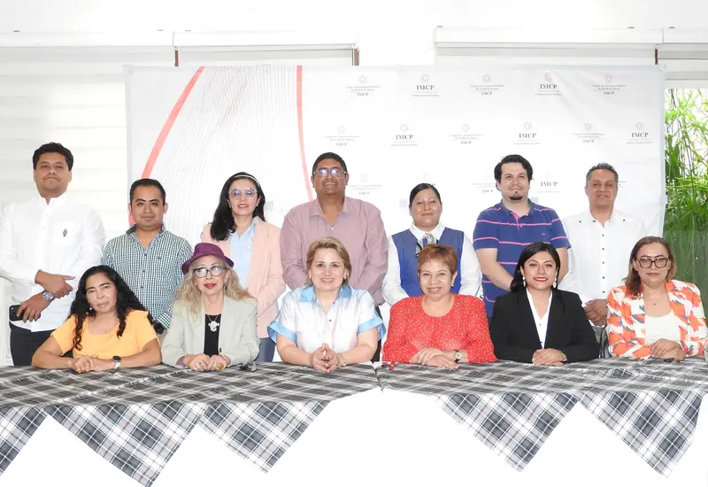 Ludivina Leija Rodríguez y Lilia Hernández Díaz, presidentas de contadores, posan sentadas durante su reunión con socios del Colegio de Contadores de Oaxaca.