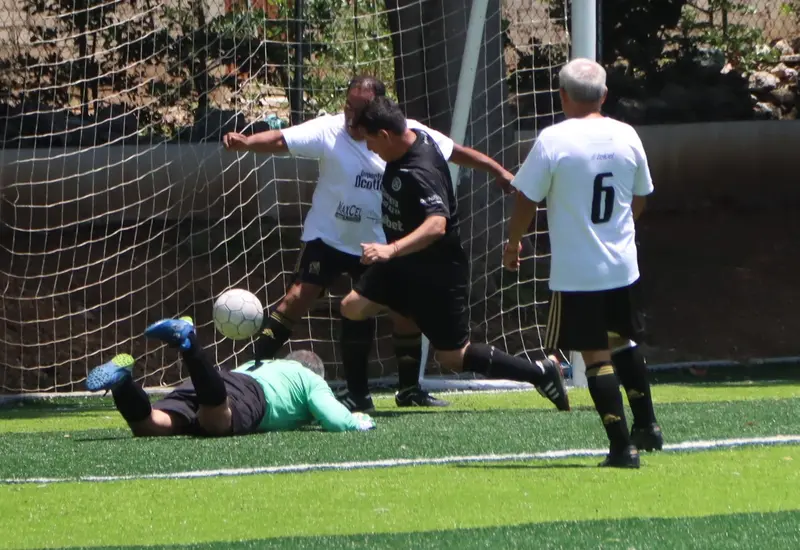 Jugadores de los equipos SCK Lomas y Los Dones disputan el balón durante un partido de la jornada siete de la Liga Futbol Premier Dominical.