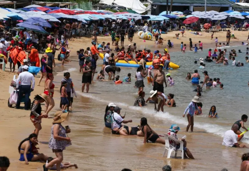 Una playa mexicana concurrida por turistas durante la temporada de verano, representando la derrama económica récord que espera la Sectur este año.
