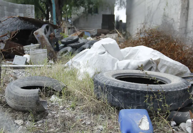 Una acumulación de cacharros y recipientes abandonados llenos de agua de lluvia, que sirven como criadero para el mosquito transmisor del dengue.