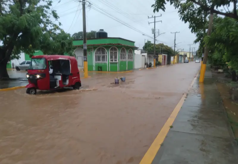 Una calle en Tehuantepec se encuentra completamente inundada por las fuertes lluvias, afectando viviendas y colonias debido a la crecida de los arroyos.